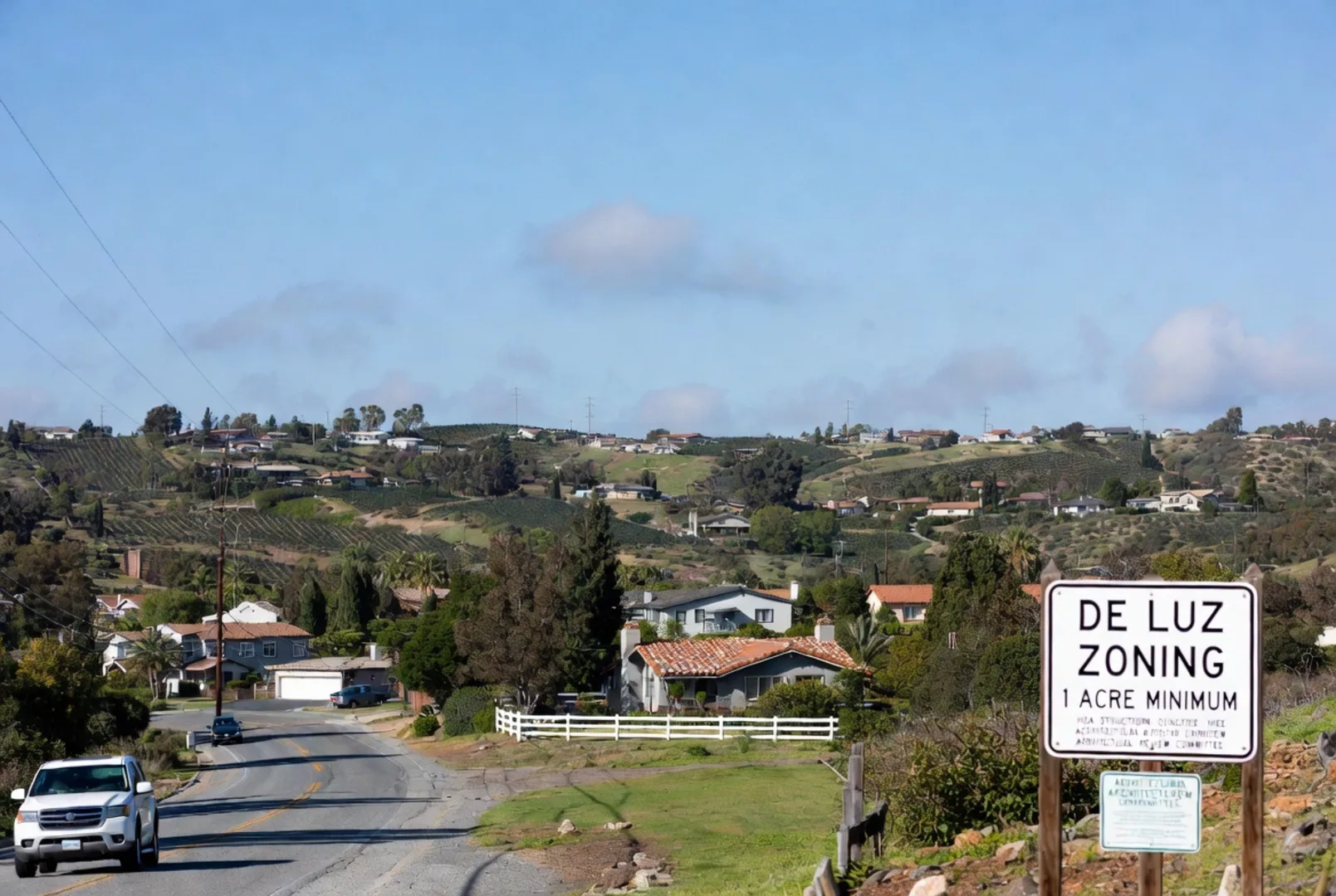 De Luz Zoning 1 Acre Minimum sign with community homes and avocado groves on rolling hillside, Temecula CA