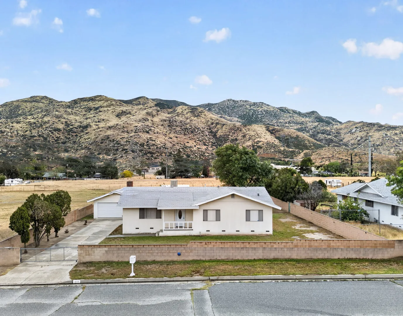 Daytime front of the home with manicured lawn and mountain ridge behind — 514 E Victory St, Banning, CA 92220